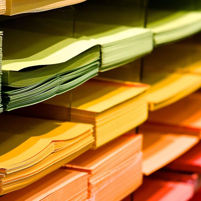 Briefpapier in verschiedenen Farben, das in Fächer aufgeteilt ist.
